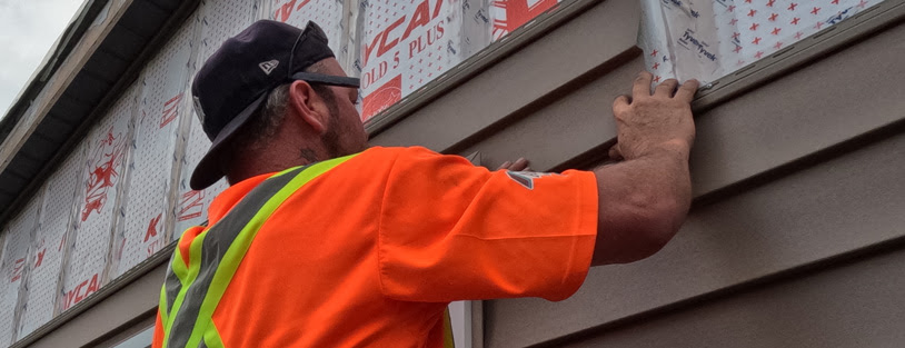 Image of Aurora Exteriors Inc Contractors installing siding on a residential home in Chatham Ontario on Faubert Drive.