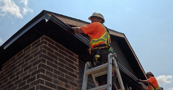 Aurora Contractors Working to Install Seamless Eavestrough to the roofline of a new construction home in Chatham-Kent.