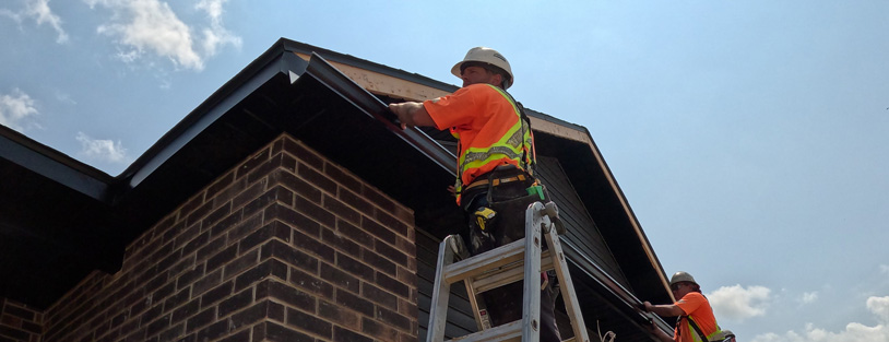 Aurora Contractors Working to Install Seamless Eavestrough to the roofline of a new construction home in Chatham-Kent.