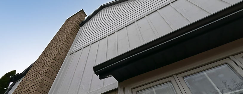 Image of white engineered board and batten siding, showing the textured of the product and the smooth clean lines