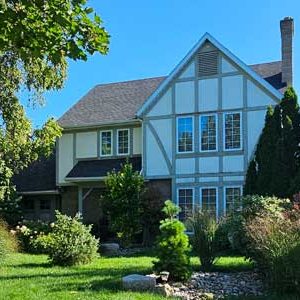 An image of a Tudor Style Home before a exterior renovation by Aurora Exteriors Inc.