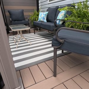 Image of the upper seating area of a multilevel deck constructed by Aurora Exteriors Inc. in from composite decking in a sand colour