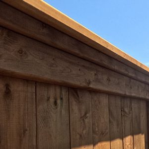 Traditional Vertical Pressure Treated Wood Fence with Black Aluminum Post Caps
