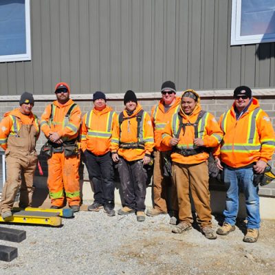 Image of Current Aurora Exteriors Employees On a Job site posing for a group picture.